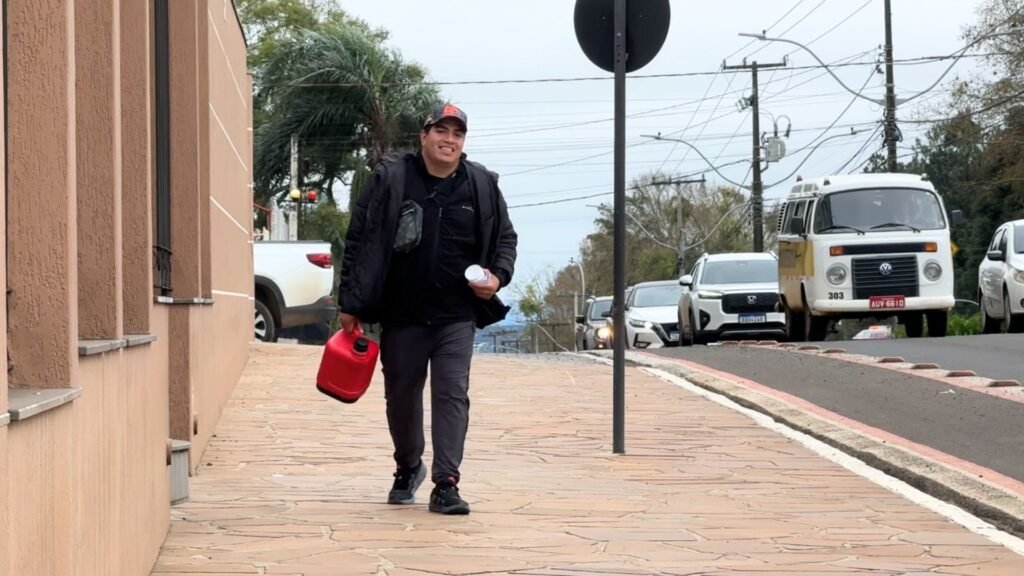 Gabriel oferecendo café a motoristas durante fechamento do semáforo na Avenida Manoel Ribas, em Guarapuava. Foto: William Batista/ Atento News