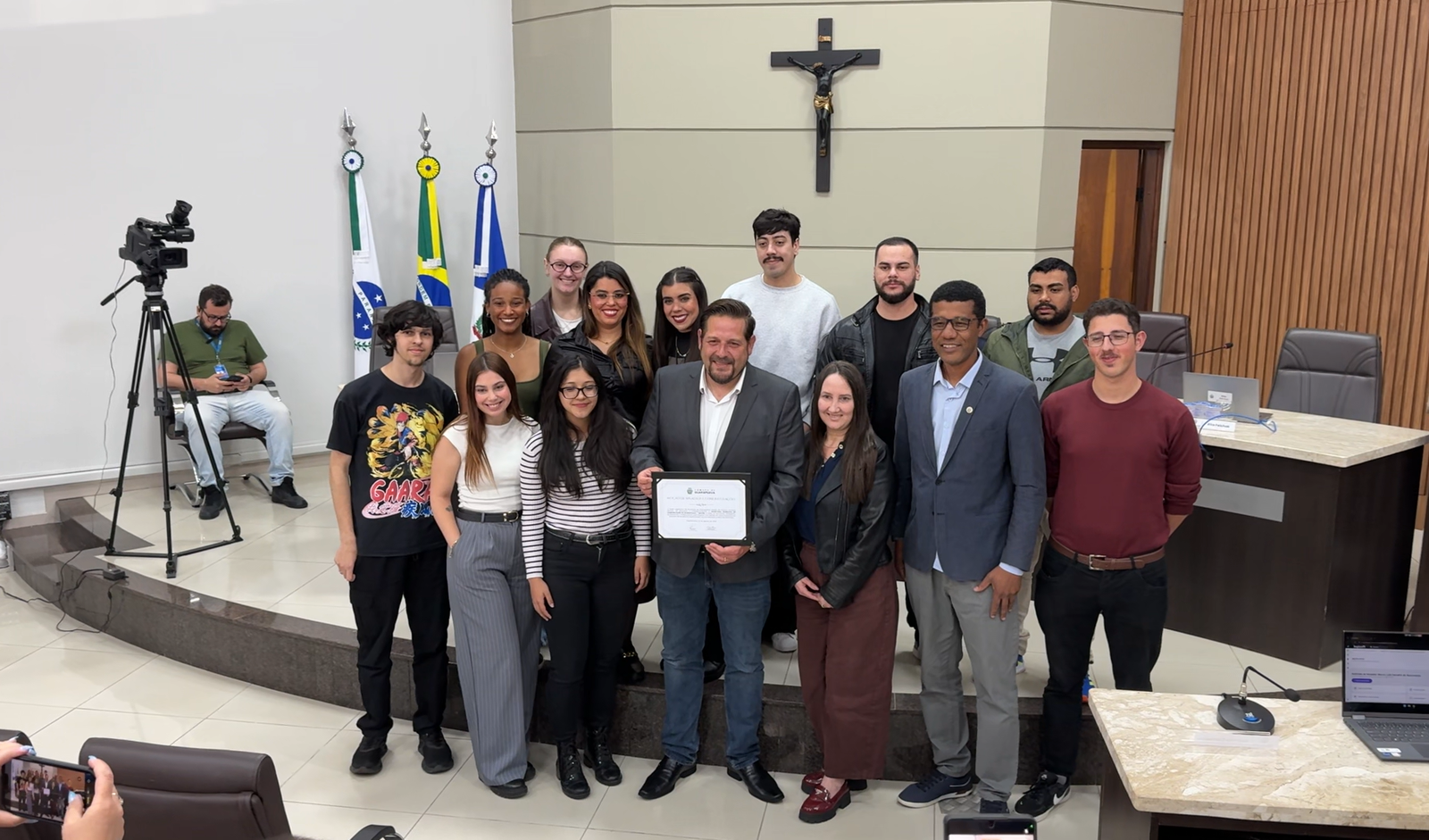 O secretário municipal de Comunicação de Guarapuava, Rafael Markus, acompanhado de integrantes da equipe da Secom e do vereador Nego Silvio, autor da proposta de homenagem, durante a entrega da moção de aplausos e congratulações na Câmara Municipal, nesta terça-feira (27). Fotos: William Batista/ Atento News